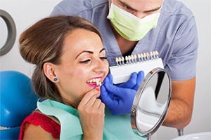 A woman looking at different veneers