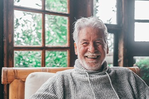 Senior man in sweater sitting in a cabin