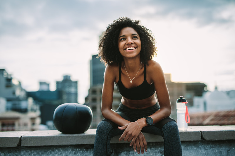 Patient smiling with medicine ball after getting dental implants